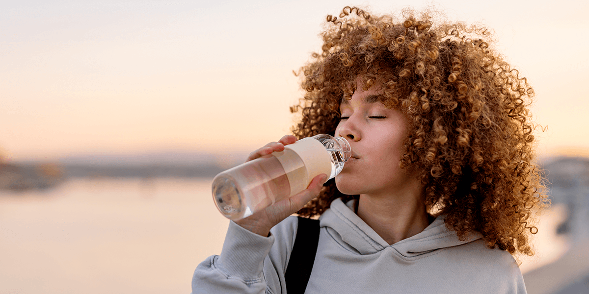 Women outside drinking water from a bottle