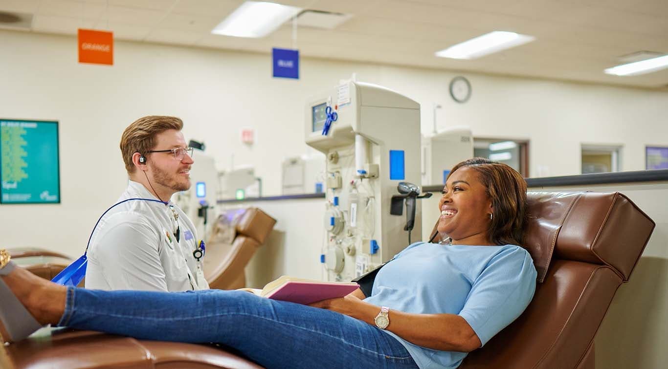 Phlebotomist talking to women in donation bed